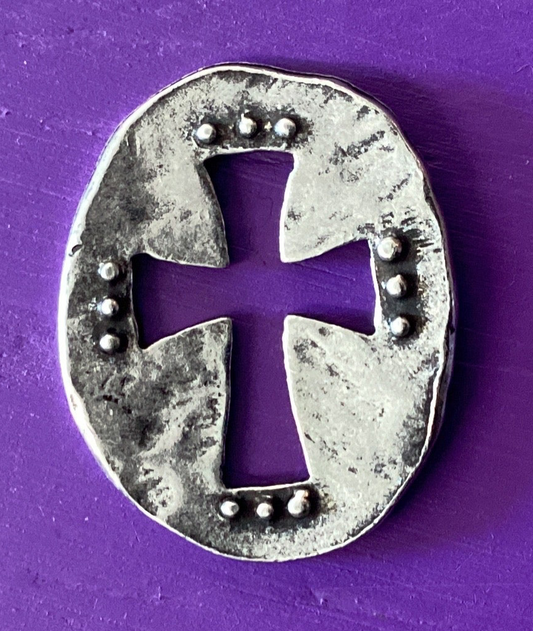 Silver horseshoe with a cross design on a purple background