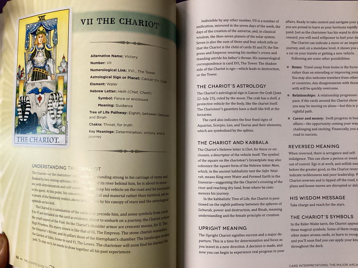 An open book spread showing the astrological chart and text for 'VII The Chariot' from The I Ching. The left page features a colorful illustration of the Chariot with the title 'THE CHARIOT' at the bottom, and the right page contains detailed astrological and kabbalistic interpretations in black text on white paper.