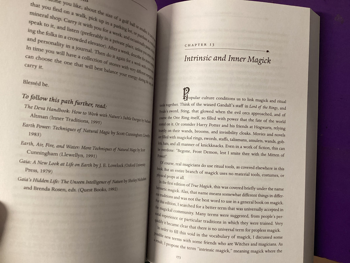 An open book showing printed text pages, with a purple cloth or book edge visible along the right side. The left page has a section titled 'Blessed be.
